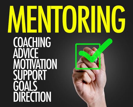 Hand holding a marker with Mentoring conceptの写真素材