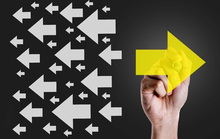 Hand holding a marker with arrows conceptの写真素材