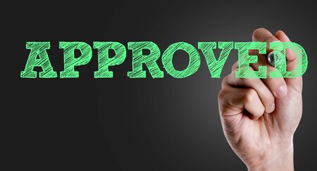 Hand holding a marker with Approved conceptの写真素材