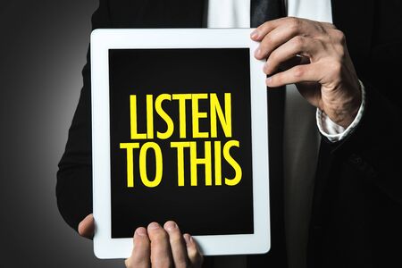 Man holding tablet with listen to thisの写真素材