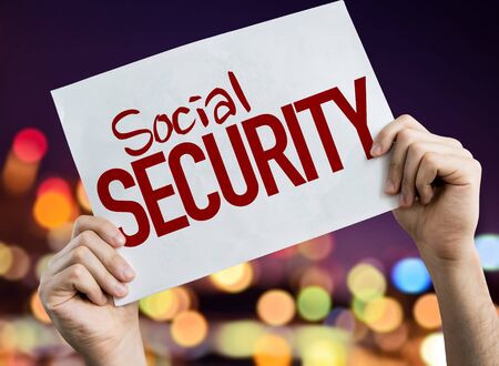 Hands holding Social Security placard with bokeh backgroundの写真素材