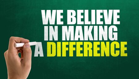 Man writing the words We Believe In Making A Differenceの写真素材