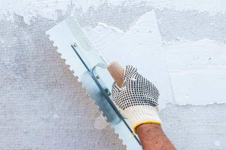 Builder using plastering tool for finishing wall and floor