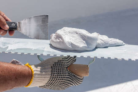 Builder using plastering tool for finishing wall and floorの写真素材