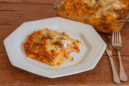 Traditional italian lasagna with cheese. On a wooden backgroundの写真素材