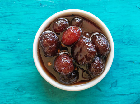 Delicious sweet gooseberry with syrup on white bowl. Blue backgroundの写真素材