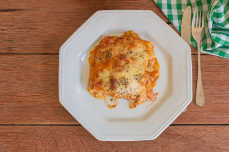 Traditional italian lasagna with cheese. On a wooden backgroundの写真素材