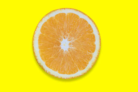 Orange cut into pieces isolated on yellow background. Close-up texture. Copy space. Clipping Pathの写真素材