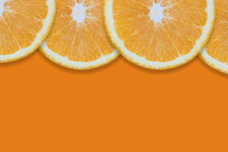 Oranges cut into pieces. Close-up texture. Copy space. Orange backgroundの写真素材