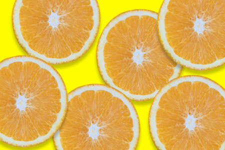 Oranges cut into pieces. Close-up texture. Copy space. Yellow background. Clipping Pathの写真素材