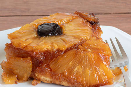 Caramelized pineapple cake with plums. Texture. Close-up. Piece of cakeの写真素材
