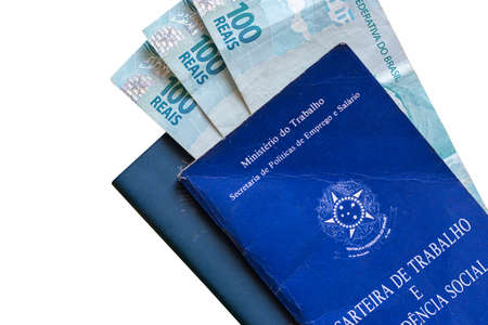 Brazilian Work Card with Brazilian money isolated on white background. Written in Portuguese Federative Republic of Brazil, Ministry of Labor. Work and Social Security card. Brazilian work conceptの写真素材