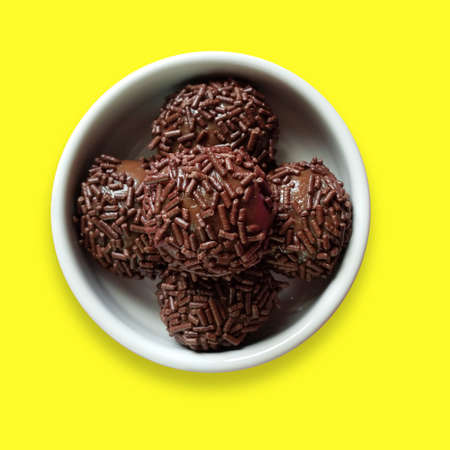 Brigadeiro. Traditional Brazilian sweet. Isolated on yellow backgroundの写真素材