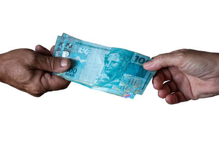 Brazilian bank notes. One hundred reais. Man's hand and woman's hand holding one hundred reais notes with white backgroundの写真素材