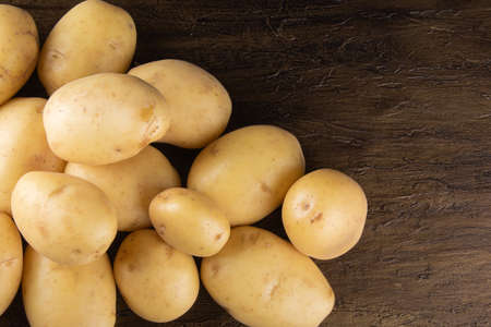 Pile of potatoes lying on rustic background. Top viewの写真素材