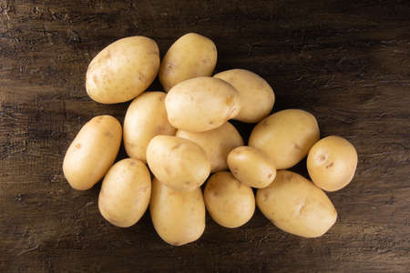 Pile of potatoes lying on rustic background. Top viewの写真素材