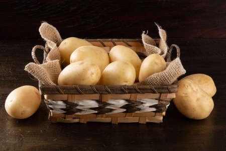 Pile of potatoes in the basket on rustic backgroundの写真素材