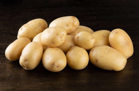 Pile of potatoes lying on rustic background.の写真素材