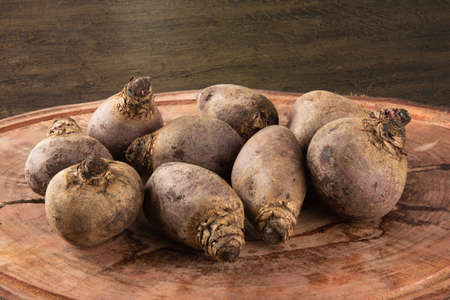 Pile of beets on wooden board and rustic backgroundの写真素材