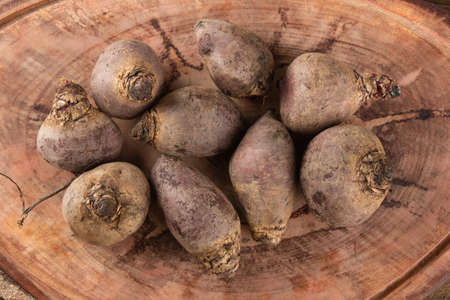 Pile of beets on wooden board and rustic background. Top viewの写真素材