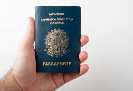 Hand holding Brazilian passport with white backgroundの写真素材