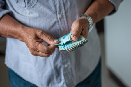 Man holding Brazilian money banknotes by handの写真素材