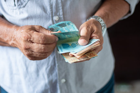 Man holding Brazilian money banknotes by hand