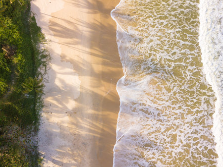 Aerial top view of sandy beach with stunning waves