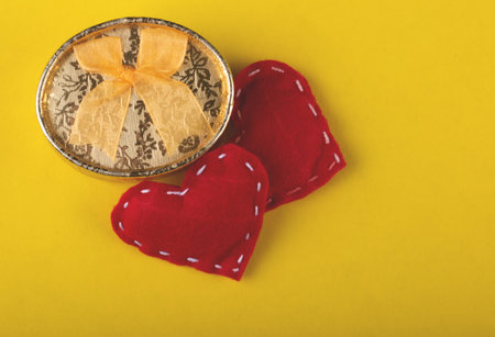 Valentine's gift with red hearts on yellow backgroundの写真素材