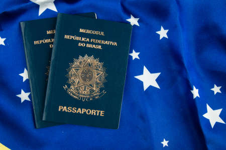 Brazilian passport with Brazilian flag in the background.の写真素材