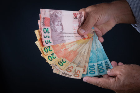 Man holding Brazilian money banknotes Finance concept.