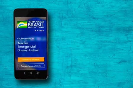 Bahia / Brazil - 02/03/2021: Brazilian Government Emergency Aid on Caixa Bank App .. Text: Emergency assistance to workers.のeditorial素材