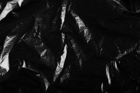 Black crumpled plastic texture background.