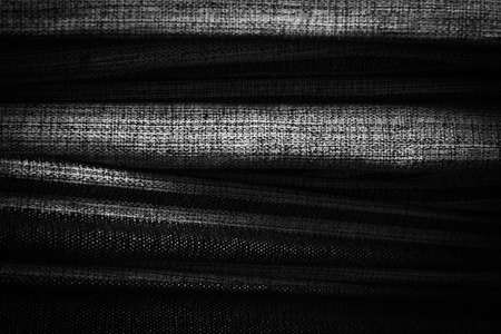 Black background with wavy fabric texture.の写真素材