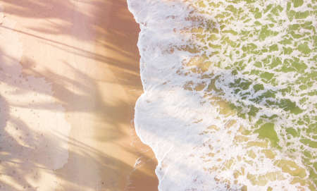 Drone aerial view beach waves at sunset.の写真素材