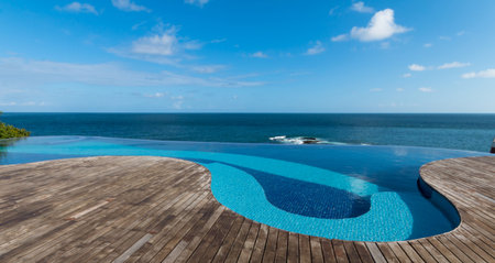 View of infinity pool to the sea and blue sky.