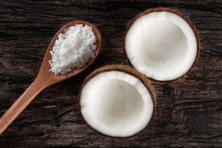 Broken dry coconut isolated over rustic wood..