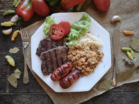 Traditional Brazilian food dish with barbecue, beans, rice and salad.
