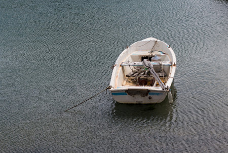 Small wooden fishing boat moored in the sea.