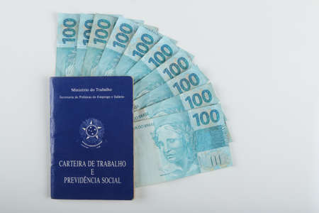 Bahia, Brazil. August 27, 2021. Brazilian work card and Brazilian money. TRANSLATION: Federative Republic of Brazil, Ministry of Labor. Work record booklet and Social Welfare..の写真素材