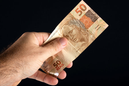 Brazilian money. Hand holding 50 reais banknotes. Brazilian finance concept..