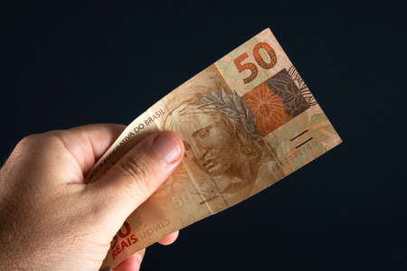 Brazilian money. Hand holding 50 reais banknotes. Brazilian finance concept..の写真素材