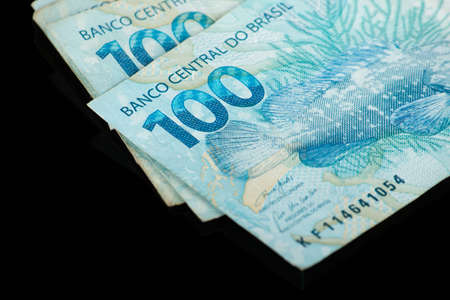 Brazilian money. One hundred reais banknotes with black background. finance concept.の写真素材