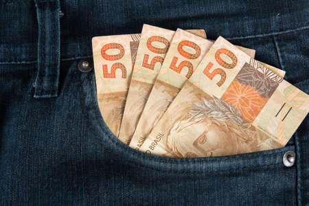 Finance concept. Brazilian fifty reais banknotes in the pocket of jeans.の写真素材