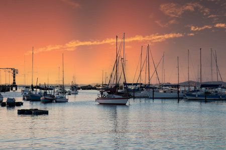 Sunset with sailboats anchored at the edge of the Ribeira in Salvador Bahia Brazil.