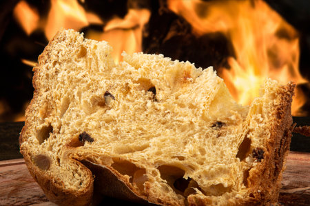Sliced panettone on wood with blurred fire background.の写真素材