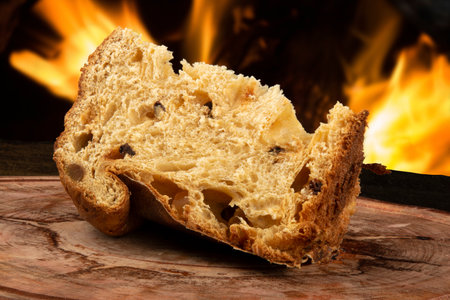 Sliced panettone on wood with blurred fire background.の写真素材