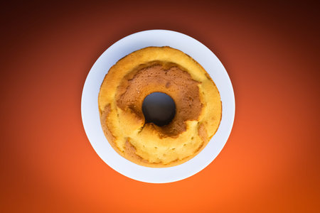 Homemade cake isolated top view with gradient orange background.