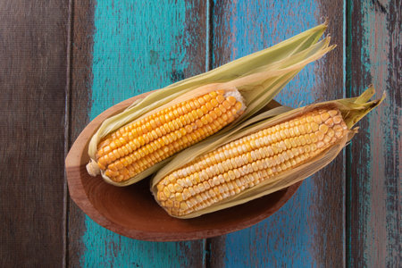 Fresh corn isolated on wood top view.