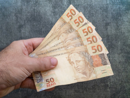 Hand holding fifty reais banknotes. brazilian money.の写真素材